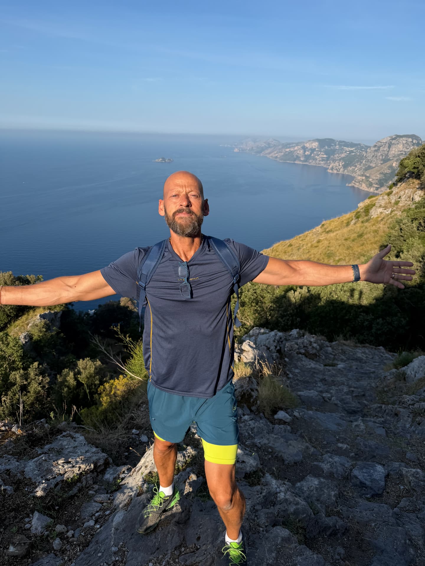 James Wyatt hiking above the coast with the sea and mountains behind him