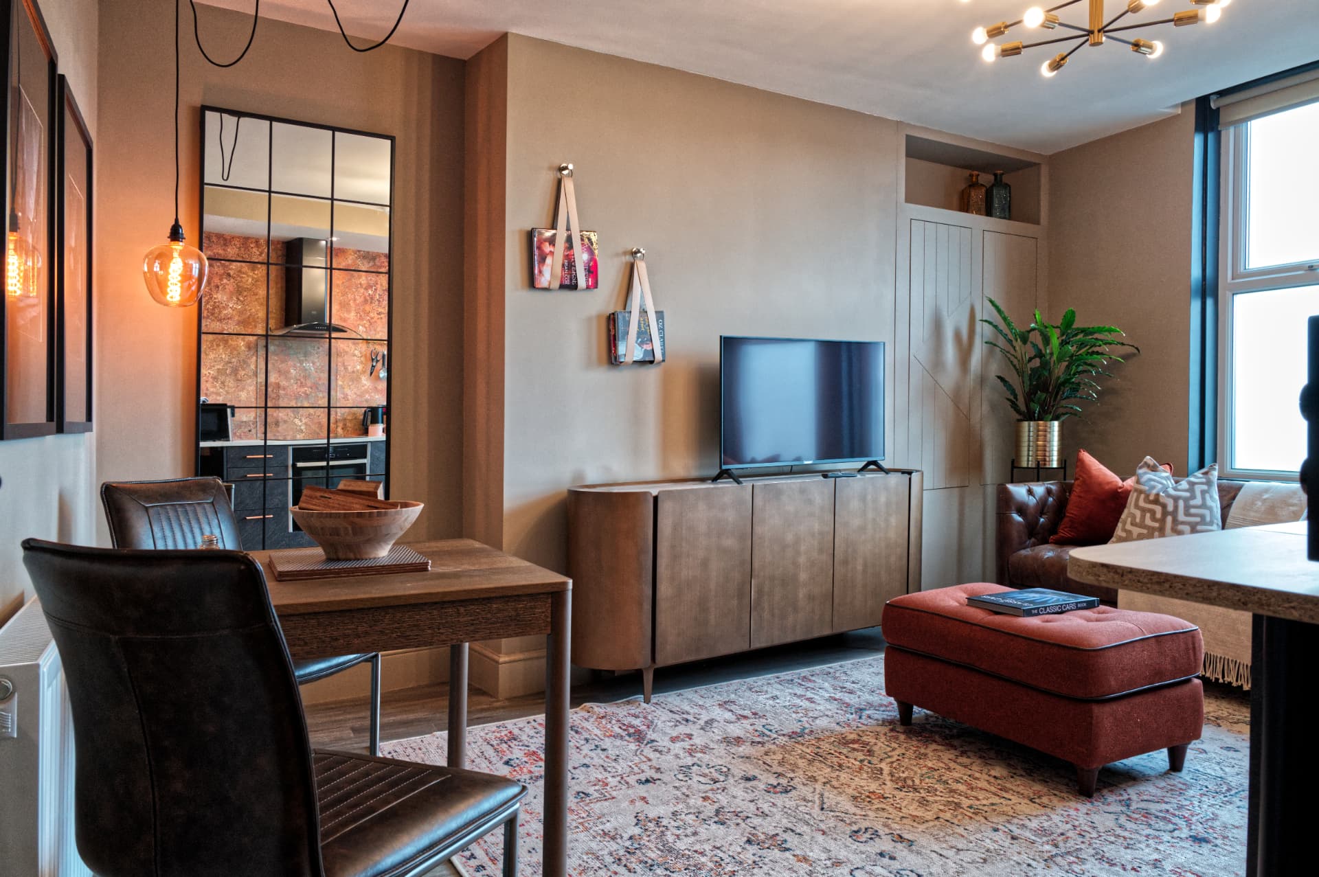 Autumn suite living area at a Soulful Stays serviced apartment in Darlington, with a leather sofa, copper footstool and warm lighting